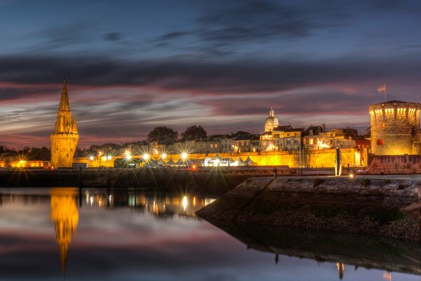 Nasyp rzeki zalany wieczornymi światłami w La Rochelle