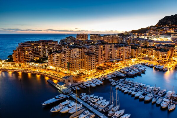 Fonvey, Principauté de Monaco. Ville du soir sur la côte d Azur, entourée d eau, sur fond de montagnes