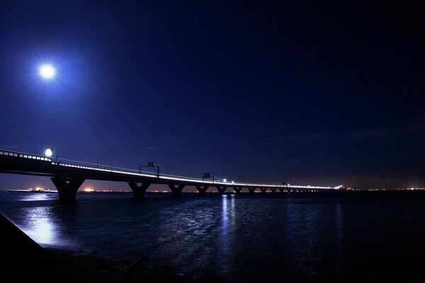 Luces nocturnas de la ciudad, luz reflejada desde el puente