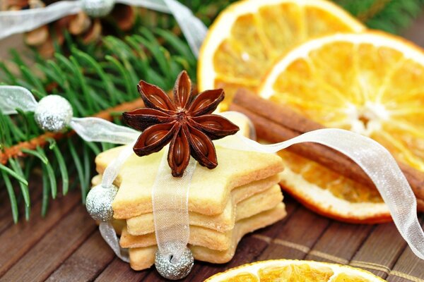 Galletas bellamente decoradas contra naranjas y ramas de abeto