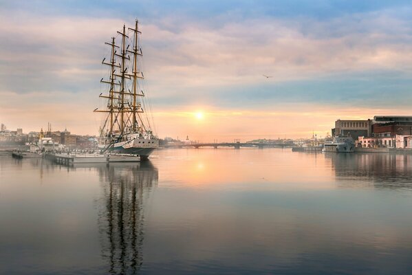 Schiff mit gesenkten Segeln bei Sonnenaufgang