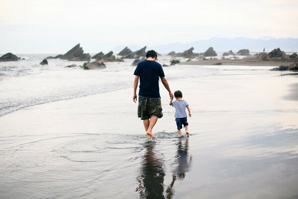 Family on a walk on the beach. Father and son