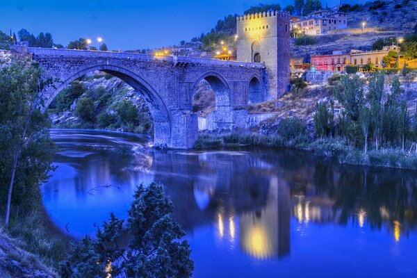 Lichter in Toledo, Spanien. Abend, Fluss und Brücke