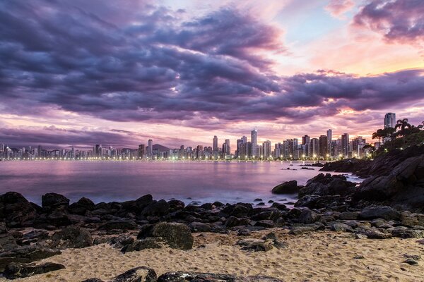 Luces de la ciudad nocturna en la playa salvaje