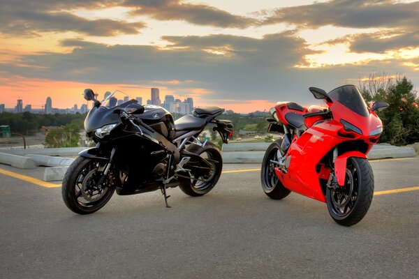 Red and black sportbikes in the city at sunset