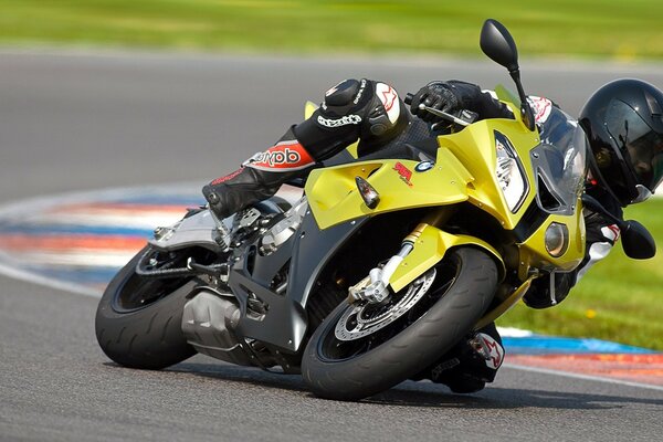 Motorcycle bmv s1000rr yellow in a steep repeat on the track