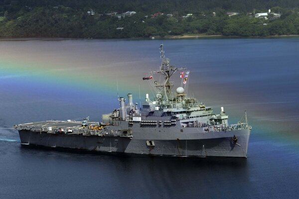 Ein Kriegsschiff im Meer mit einem bunten Schatten des Regenbogens