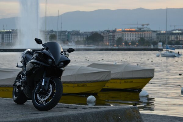 Schwarzes Yamaha-Motorrad am Wasser. Der Brunnen. Boote am Pier