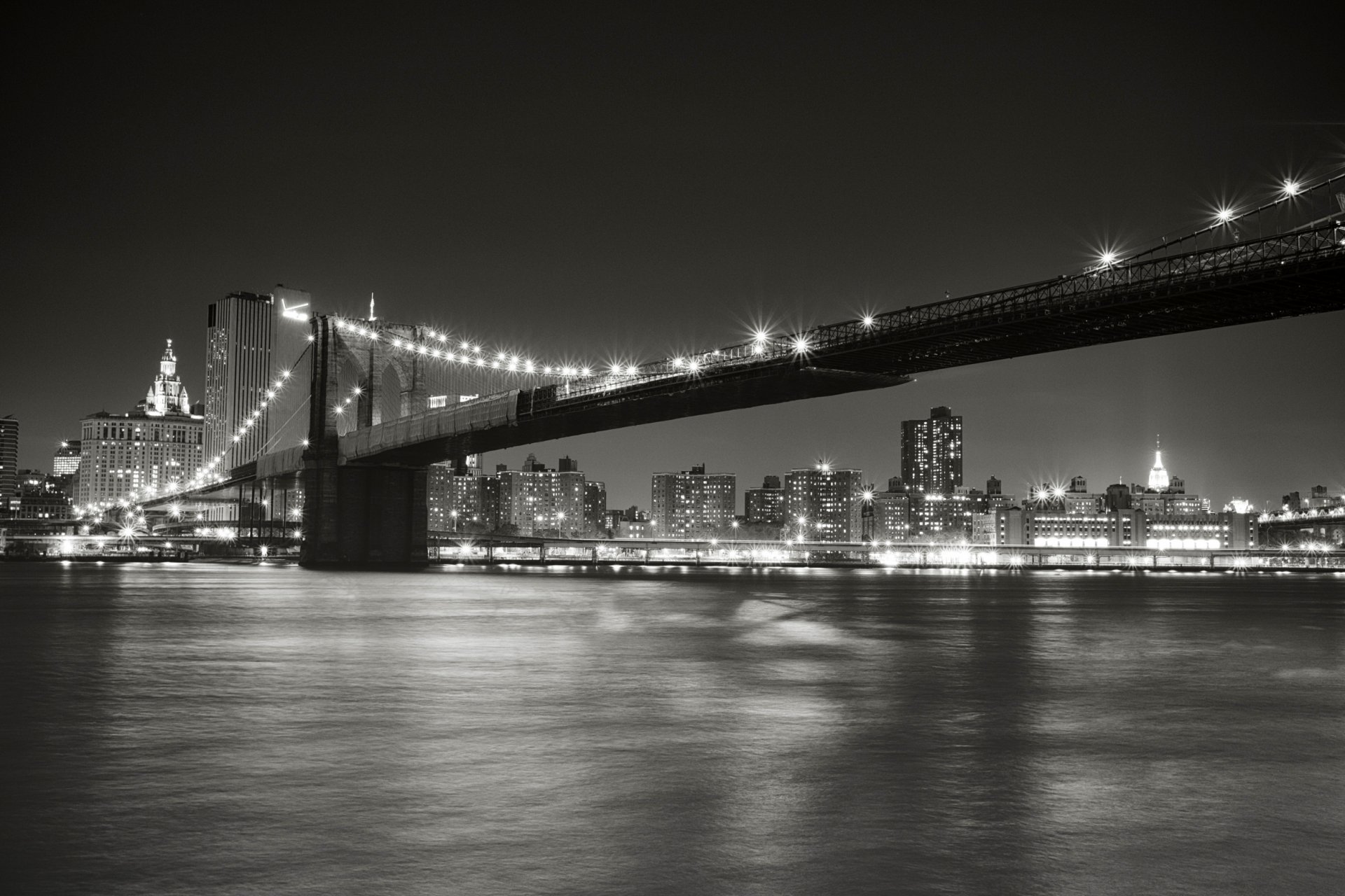 new york usa brooklyn bridge east river strait manhattan city night lights lighting black and white