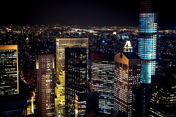 Nueva York luz de fuego en la noche. Edificios de Manhattan, rascacielos con rascacielos iluminados. Estados Unidos ciudad ventanas panorámicas 