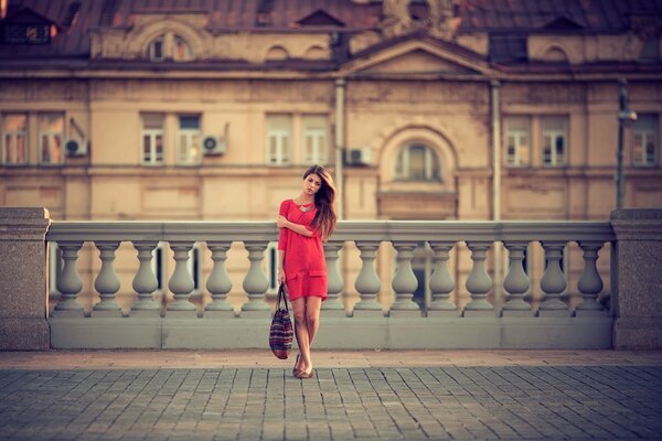 Una chica de rojo camina por las calles de Moscú