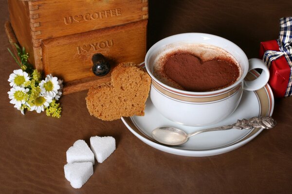 Café chaud dans une tasse avec une pincée de chocolat en forme de coeur