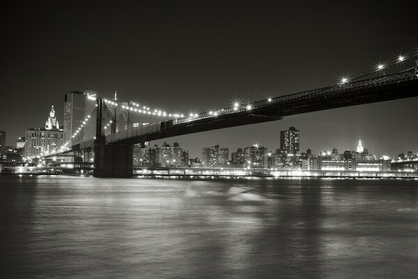 The Brooklyn Bridge is depicted in black and white