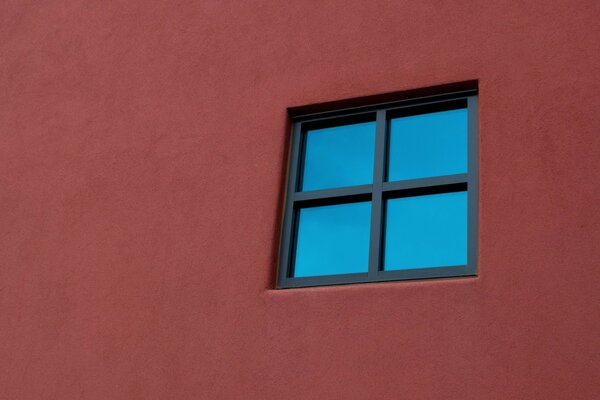 Schwarzes Fenster an der roten Wand (Minimalismus)