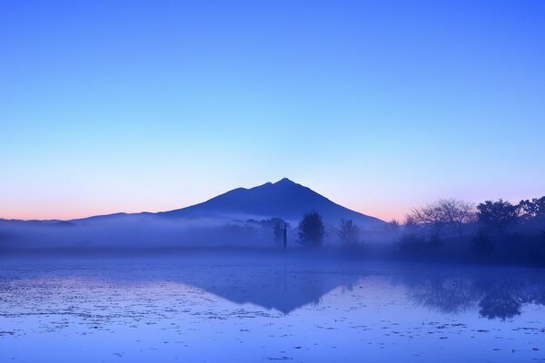 Riflessione serale della montagna e degli alberi nel lago