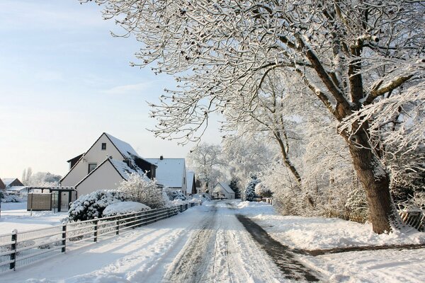 Strada invernale nel villaggio lungo la recinzione