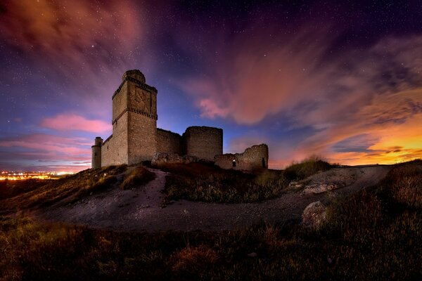 Château de pierre sur une colline sous un ciel fantastique