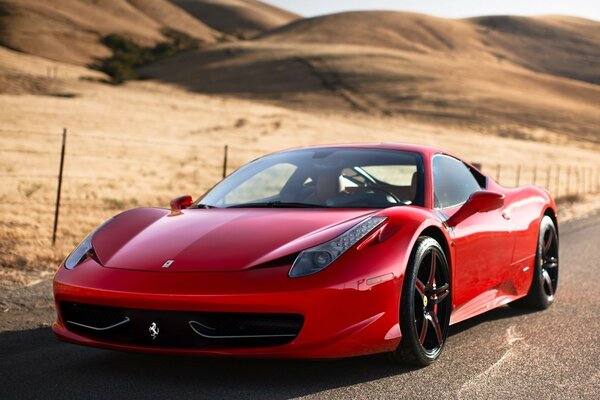 A red Ferrari is driving on a deserted road