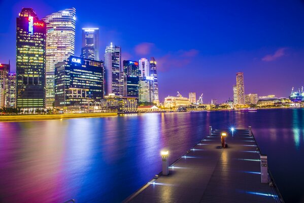 Rascacielos de Singapur en la noche cerca del muelle