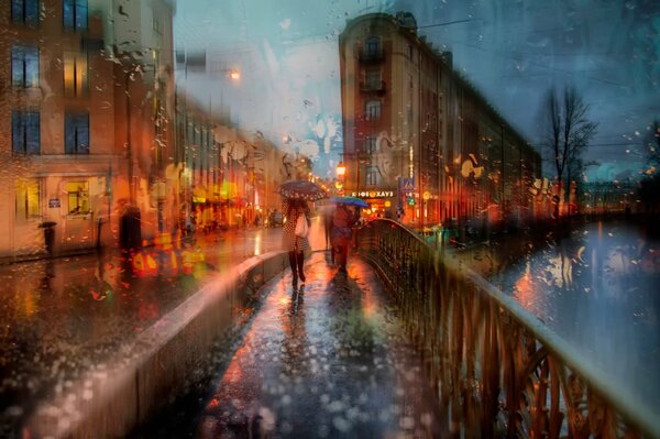 Two girls with umbrellas on a bridge in the rain