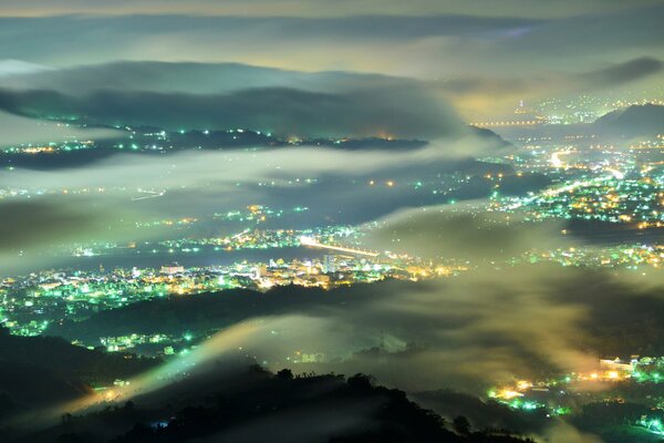 Blick auf die Lichter der Stadt im Nebel in der Nacht