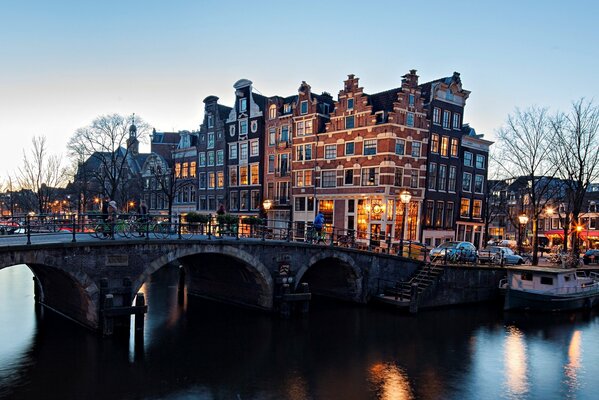 Pont sur la rivière à Amsterdam, éclairé par des lanternes du soir