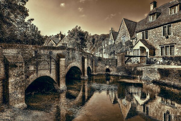 Bearbeitetes Schloss in England über eine Brücke, die durch einen Fluss führt