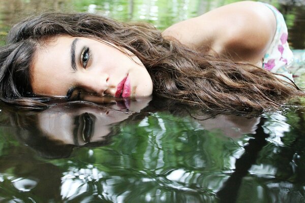 Fille avec maquillage dans le reflet de l eau