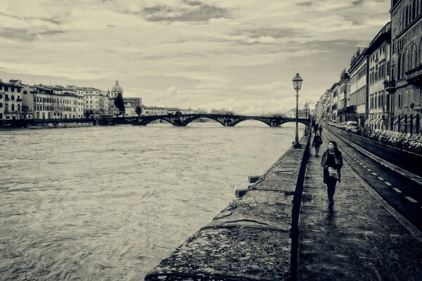 Czarno-biały krajobraz promenady we Florencji z przechodniami