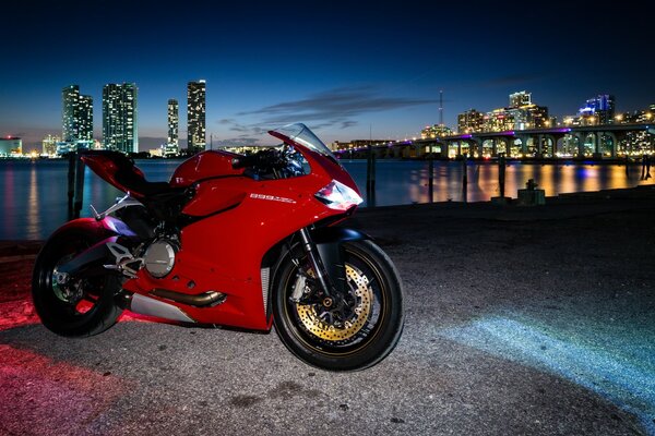 Rotes Motorrad auf dem Hintergrund der spät Sonnenuntergang Stadt