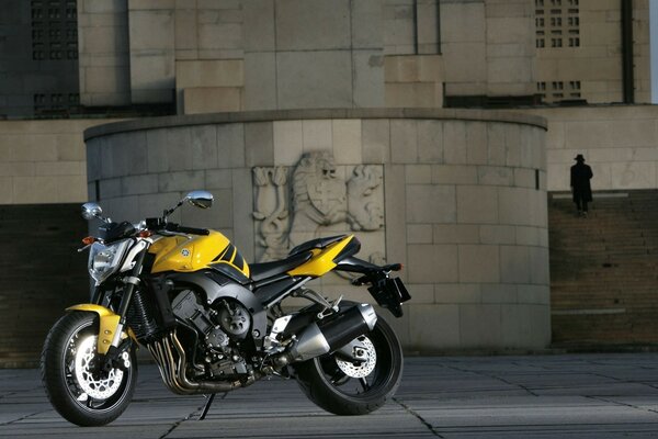 Classic sports bike Yamaha at the stone walls of a boring city