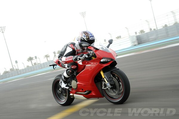 Coureur sur une moto de sport Ducati rouge