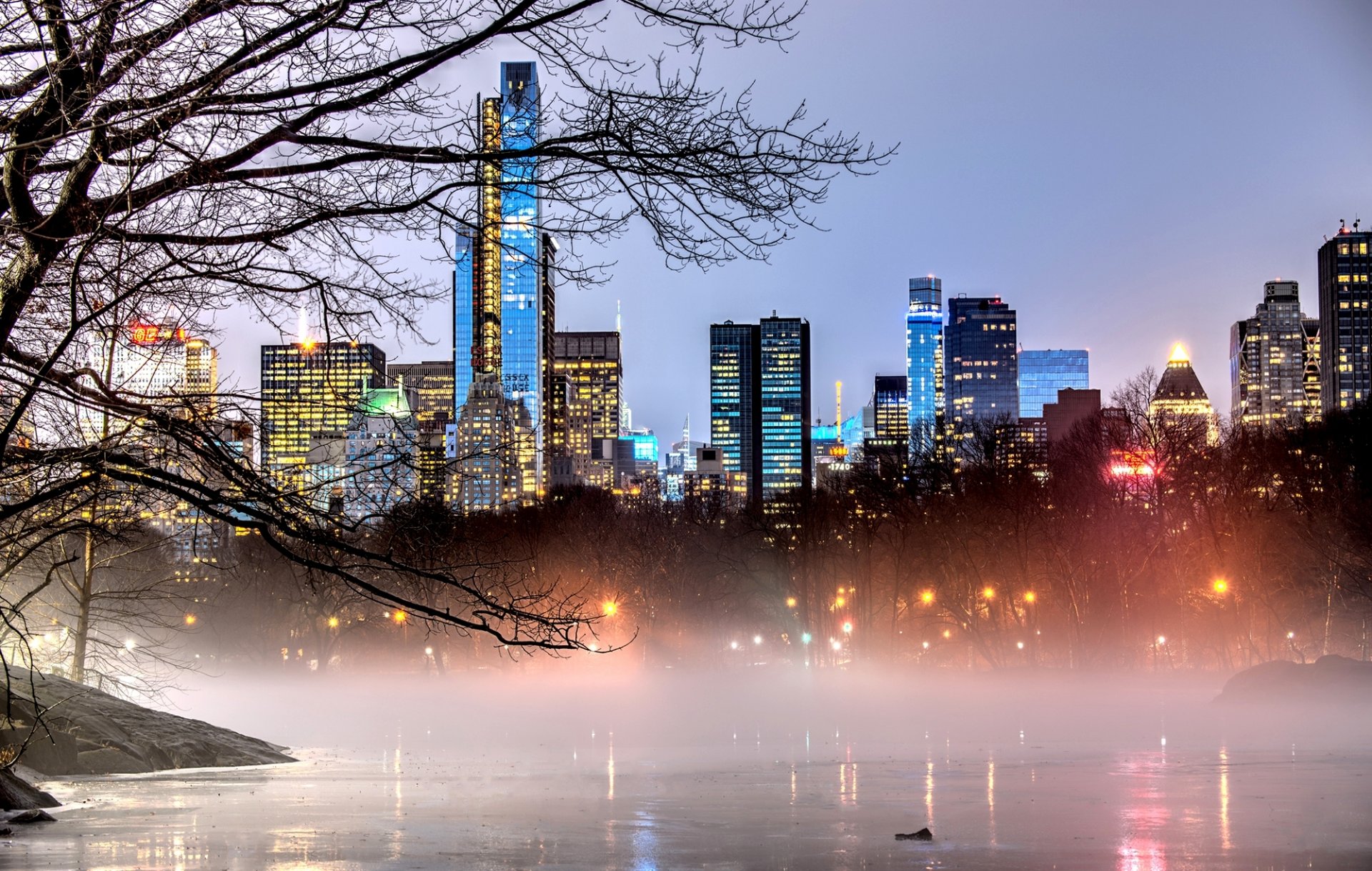 nowy jork manhattan central park usa miasto wieczór drzewa gałęzie światła mgła natura park jezioro budynki domy drapacze chmur