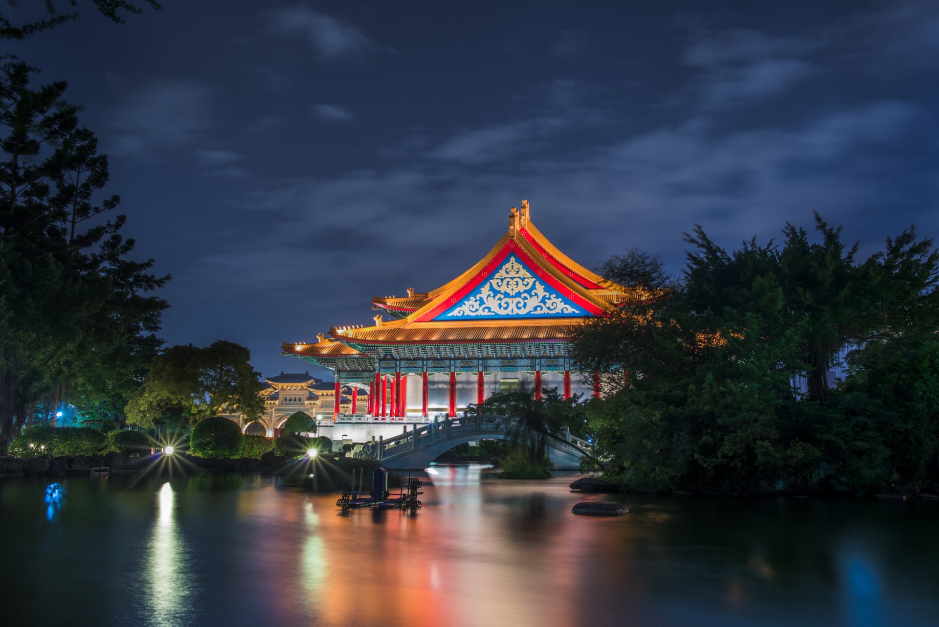 taiwan taipei théâtre national bâtiment architecture jardin arbres pont étang nuit éclairage bleu ciel nuages