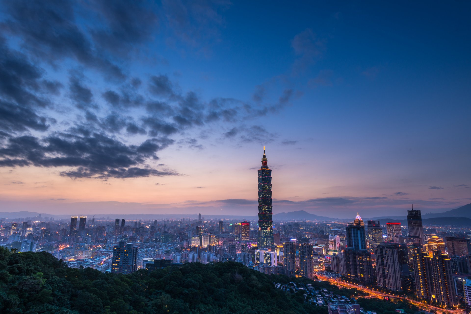 china taiwán taipei ciudad tarde crepúsculo colinas azul cielo nubes puesta de sol torre edificios casas luces iluminación vista altitud panorama