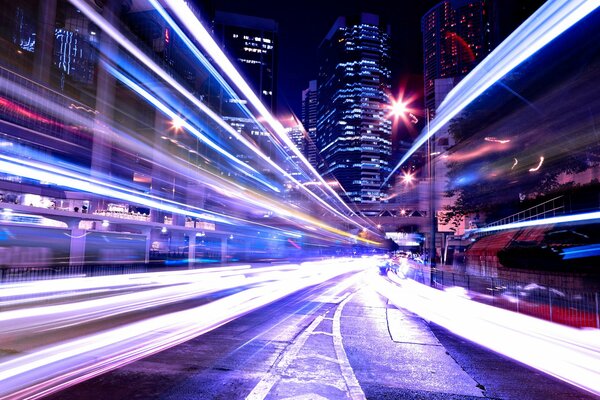 Luces de la pista nocturna y edificios dormidos de la metrópoli