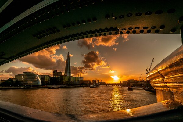 Sonnenuntergang in London unter einer Brücke am Fluss