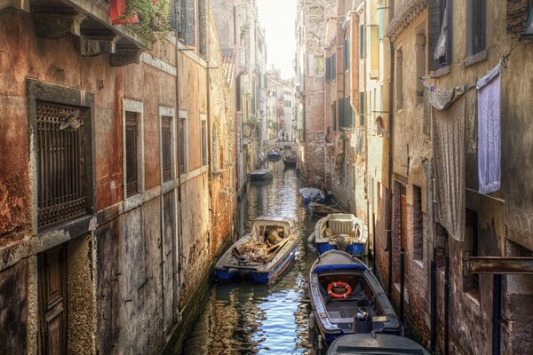 Boats in the canal between houses in Venice