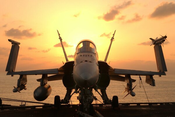 McDonnell-Douglas fa-18 sur fond de mer et coucher de soleil