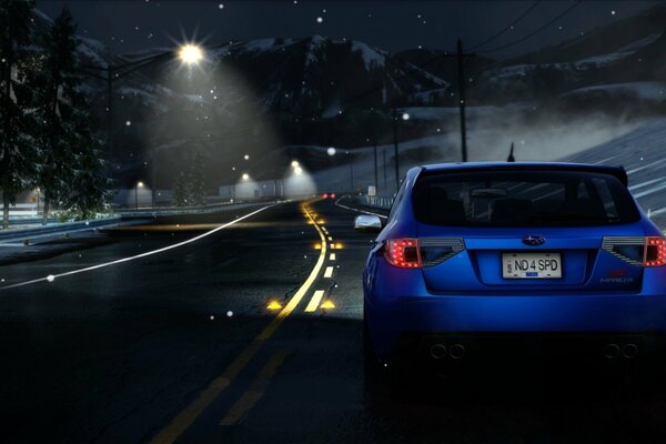 A blue subaru on an empty night road