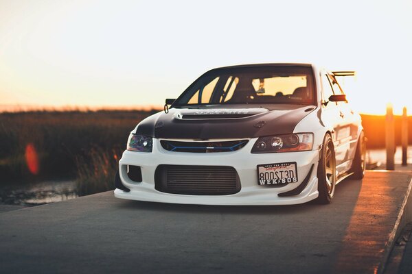 Mitsubishi lancer on the bridge and sunset behind