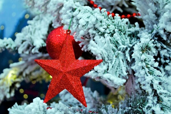 Estrella roja en un árbol de Navidad cubierto de nieve