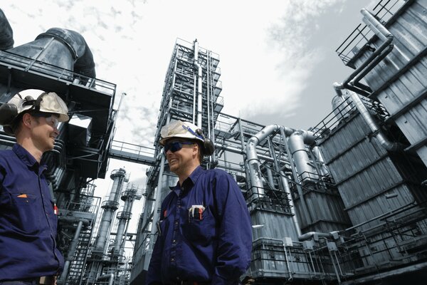 Ingénieurs au travail. Hommes en uniforme sur fond de construction industrielle