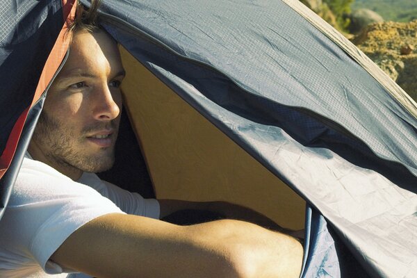 Hombre en una tienda de campaña, camping