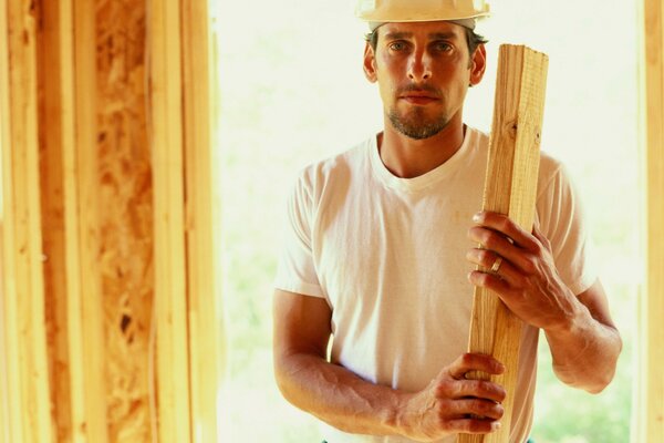 Maître constructeur dans un casque tenant une planche