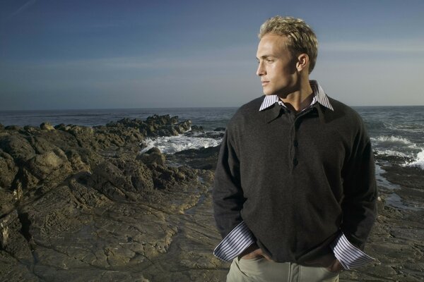 Blonde against the background of the sea and rocks