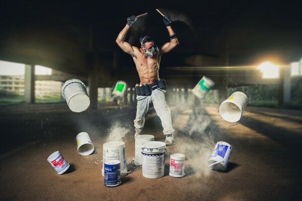 A man plays on cans of paint