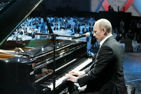 Vladimir Putin at the piano with a microphone