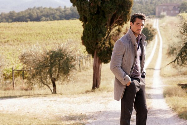 A handsome man against the background of the road and the sun-scorched nature