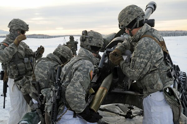 Artilleros disparan un gran cañón de 105 mm